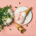 Pink strawberry and coconut ice cream, waffle cones, peony flowers Royalty Free Stock Photo