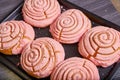 Pink strawberry pastry baked good Mexican sweet bread conchas seashell swirl frosting pattern