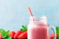 Pink strawberry smoothie or milkshake in mason jar on turquoise table. Healthy food for breakfast and snack. Royalty Free Stock Photo