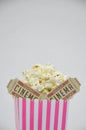 Pink Striped Box of Popcorn with Two Cinema Tickets Inside Royalty Free Stock Photo