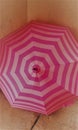 Pink striped umbrella drying in the corner of the cafe