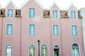 Pink stucco house with a white framed windows and a lamppost in front Royalty Free Stock Photo