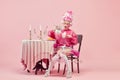 Portrait of elegant princess, queen wearing pink clothes, and wig drinking tea over pink background. Pink style festive Royalty Free Stock Photo