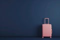 a pink suitcase is sitting in front of a blue wall