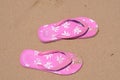 Pink summer slippers on the beach