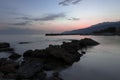 Pink sunset on the beach in Creta, Greece. A beach with blacks rocks and waves at dusk Royalty Free Stock Photo