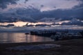 pink sunset with blue dark clouds in sky in bay of lake Baikal with jetty mole pier with old ships and boats, evening Royalty Free Stock Photo