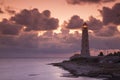 Pink sunset with clouds behind the old lighthouse