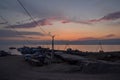 Pink sunset with clouds in the sky in bay of the lake baikal with walkway on dock pier with old ships and boats, evening, lamp