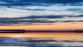 Pink sunset  on pier at sea on horizin promenade with blurred night light cloudy dramatic  blue sky and full big moon on starry sk Royalty Free Stock Photo