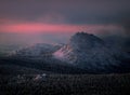 A pink sunset reflects off the mountain. Ural.