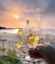 glass of water  and splas with lemon in hand on beach at pink  sunset nature landscape Royalty Free Stock Photo