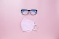 Pink surgical mask plaid and blue glasses on pink backgroud pastel style flatlay topview copyspace