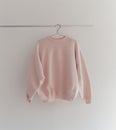 Pink Sweater Hanging on White Wall