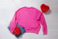 Pink sweatshirt mockup. Valentines Day concept shirt, gift box heart shape on wooden background. Copy space, template blank front