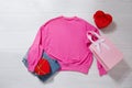 Pink sweatshirt mockup. Valentines Day concept shirt, gift box heart shape on wooden background. Copy space, template blank front