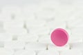 Pink tablet on other white tablets Royalty Free Stock Photo