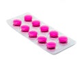 Pink tablets pills in blister pack isolated on white background.