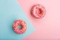 Pink tasty donuts decorated with colorful sprinkles on blue and pink background. Sweet donuts minimal flat lay Royalty Free Stock Photo