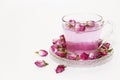 Pink tea in a clear glass mug and dry little pink rose buds