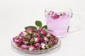 Pink tea in a clear glass mug and dry little pink rose buds
