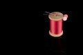 Pink Thread with two needles on top in flower shape, Cerise Pink, Wooden Bobbin isolated on Black Background, reflecting surface, Royalty Free Stock Photo