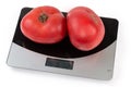 Pink tomatoes on the digital kitchen scale on white background Royalty Free Stock Photo