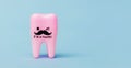 Pink tooth model on blue background. Space for text. Copy space. Close up. Dental health concept. Stomatology.