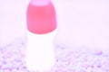 Pink top of glass roll deodorant bottle for body care on purple stones