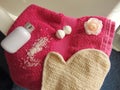 Pink towel on bathtub with bath glove