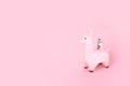 Pink toy llama money bank on monochromatic background