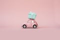Pink toy retro model car delivering gift box for Valentine`s day on pink background. Volkswagen Beetle on pink background. Royalty Free Stock Photo