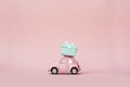 Pink toy retro model car delivering gift box for Valentine`s day on pink background. Volkswagen Beetle on pink background. Royalty Free Stock Photo