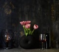 Pink tulip bouquet in black vase on table on dark background. Copy space for text Royalty Free Stock Photo