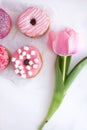 Pink tulip and dessert - donuts with pink decorations. Royalty Free Stock Photo