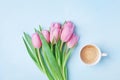 Pink tulip flowers and fresh coffee on pastel background top view. Beautiful spring breakfast on Mothers or Womans day. Flat lay. Royalty Free Stock Photo