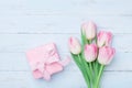 Pink tulip flowers and gift or present box on blue wooden table top view. Greeting card for Womans or Mothers Day. Flat lay. Royalty Free Stock Photo