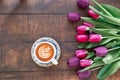 Pink tulips bouquet and coffee on wooden background. Top view with space for your text Royalty Free Stock Photo