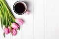 Pink tulips and coffee in a mug on the white table Royalty Free Stock Photo