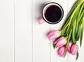 Pink tulips and coffee in a mug on the white table Royalty Free Stock Photo