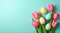 Pink Tulips and Decorated Easter Eggs Arranged on Light Turquoise Background for Spring and Festive Themes Royalty Free Stock Photo