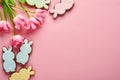 Pink tulips with easter gingerbread eggs located in a row on pink background. Floral pattern. Mock up and banner. Space for text Royalty Free Stock Photo