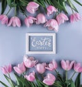 Pink tulips flowers on blue background with frame for text. Waiting for spring. Happy Easter card. Flat lay, top view Royalty Free Stock Photo