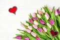 Pink tulips with red hearts on white wooden background. Copy space. Valentine Day, Wedding concept. Royalty Free Stock Photo