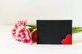 Pink tulips, red origami heart and horizontal black paper empty card with copy space Royalty Free Stock Photo