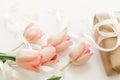 Pink tulips with ribbon and gift box on white background. Stylish soft image of spring flowers. Happy womens day. Greeting card Royalty Free Stock Photo