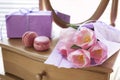 Pink tulips in violet paper, two pink macaroons, gift and mirror Royalty Free Stock Photo