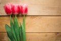 Pink tulips on wooden background. Flat lay, top view, copy space. Royalty Free Stock Photo