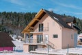 Pink two-story house in a snow-covered village on the edge of a coniferous forest Royalty Free Stock Photo