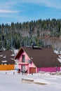 Pink two-story house with a terrace in the snow at the edge of a coniferous forest in the village Royalty Free Stock Photo